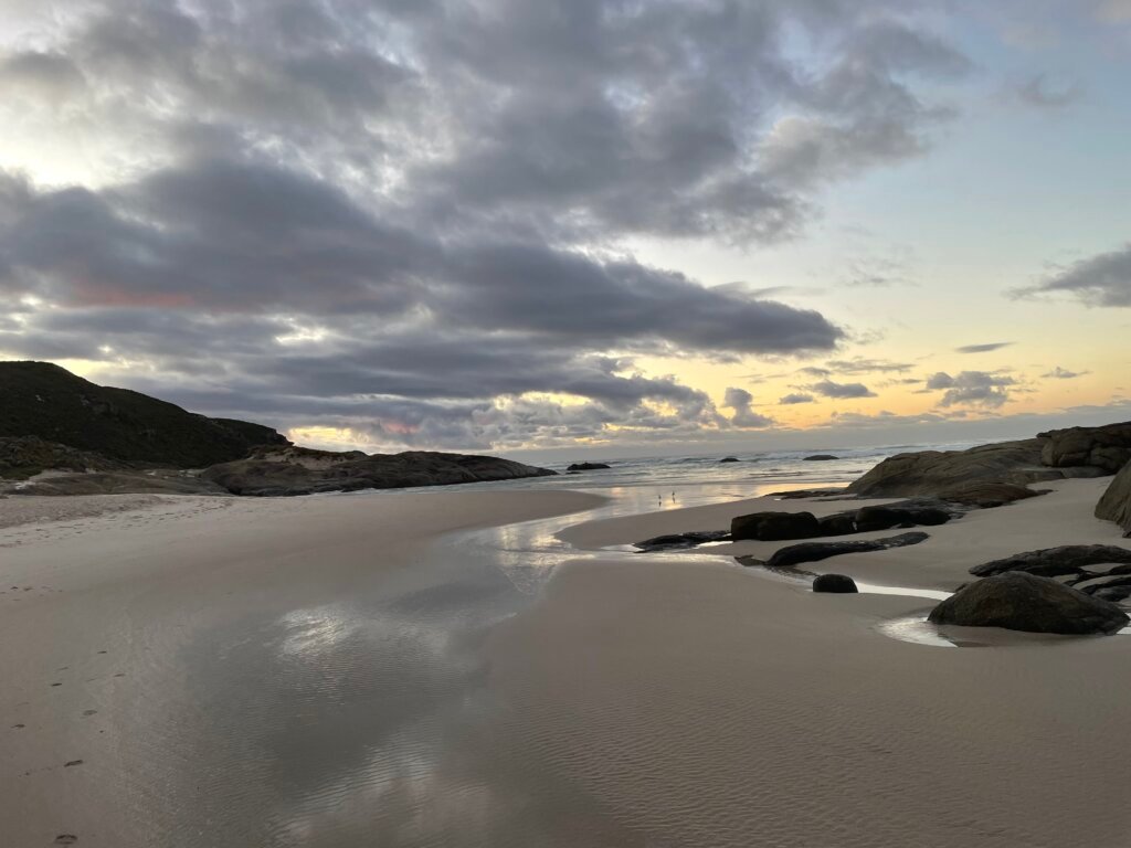 Ruhiger Strand mit Spiegelung als Symbol für Loslassen und innere Sammlung